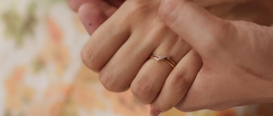 Their joined hands, the ring on her finger